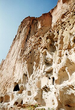 Cliff face of welded tuff pockmarked with holes — some natural, some man-made — from Bandelier National Monument, New Mexico