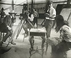 Production image showing (from left) Griffith, cameraman G. W. "Billy" Bitzer behind Pathé camera, Dorothy Gish watching from behind him, Karl Brown holding script, and Miriam Cooper in profile