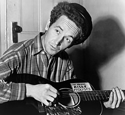 Woody Guthrie (here, with guitar labeled "This machine kills fascists," 1943) contributed a song