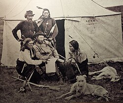 Custer and Bloody Knife (kneeling left), his favorite Indian Scout. Custer was well-liked by his native scouts, whose company he enjoyed. He often ate with them. A diary entry in May 1876 by Kellogg records, "General Custer visits scouts; much at home amongst them."[49]
