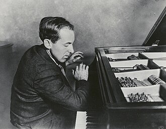 Cowell playing the piano, demonstrating his "forearm" technique by slamming down with his right arm on the middle register, c. 1920s