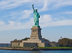The Statue of Liberty on Liberty Island in New York Harbor, a global symbol of the United States and its ideals of liberty, freedom, and opportunity[118]