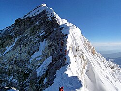 Looking up along the southern ridgeline in 2010, the face of the Hillary Step is visible. The top of the Southwest Face is on the left in shadow, and to the right is the top of the East/Kangshung Face. In 2016 and 2017 there were reports the Hillary Step was changed, which triggered discussion in the climbing community.