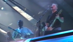 Adams (wearing white) playing guitar with David Gilmour of Pink Floyd in 1994