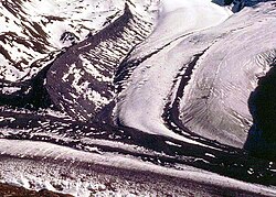 Moraines clearly seen on a side glacier of the Gorner Glacier, Zermatt, Switzerland. The lateral moraine is the high snow-free bank of debris in the top left hand quarter of the picture. The medial moraine is the double line of debris running down the centre-line of the glacier.