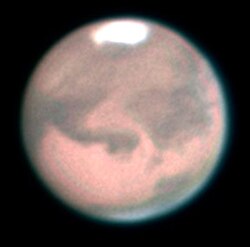 A telescopic view of Mars at full phase, featuring its prominent maria and south polar ice cap