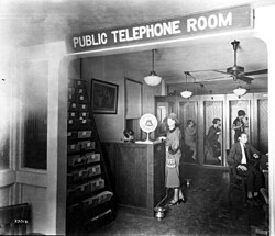 Public telephone room, Miami, Florida, 1925, with a row of telephone booths seen along the back wall. Customers would request a call at the front desk; when the connection was made the customer would be directed to go to one of the booths for the call.