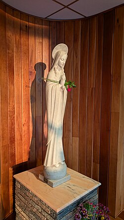 A rose left on a statue of mary to honor her at the Novitiate and College of Humanities of the Legionaries of Christ