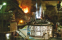 A DC arc furnace during power-on (note the single large electrode)
