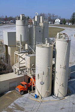 Concrete plant showing a concrete mixer being filled from ingredient silos