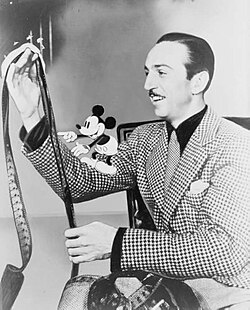 Disney with film roll and Mickey Mouse on his right arm in 1935