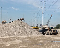 Recycled crushed concrete, to be reused as granular fill, is loaded into a semi-dump truck.