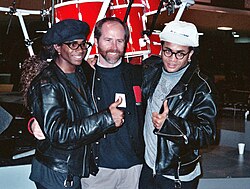The Milli Vanilli duo pose with Michael Greene, chairman of NARAS, during the 1990 Grammys rehearsal.