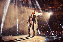 Lambert on stage with Queen at Madison Square Garden, New York City in July 2014 performing "Who Wants to Live Forever"