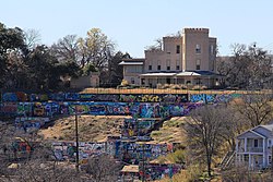 The HOPE Outdoor Gallery, overlooked by the historic Texas Military Academy building, the oldest standing educational building in Texas; the gallery has since been demolished.