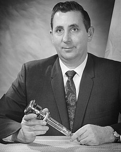 Gerhard W. Goetze holding the Secondary Electron Conduction tube (SEC) prototype