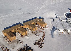 The Amundsen–Scott South Pole Station, the geographic South Pole, with its signpost in the background