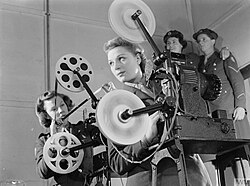 Two projectionists showing a film on a 16 mm De Vry Simplex Ampro projector in Aldershot, Hampshire, U.K., 1941.