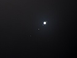 Photograph of Jupiter and its Galilean moons, showing how they appear with binoculars