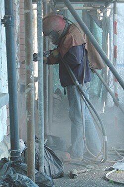 Sandblasting a stone wall