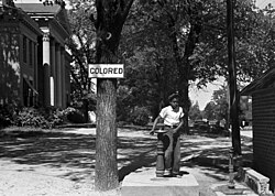 An African-American child at a segregated drinking fountain on a courthouse lawn, North Carolina, US 1938