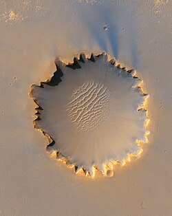 High-resolution image of Victoria crater from HiRISE on October 3, 2006. The rover Opportunity can be seen at roughly the "ten o'clock" position along the rim of the crater.