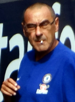 Chelsea manager and noted smoker Maurizio Sarri in 2018, chewing a cigarette butt during a Premier League match due to England's smoking ban