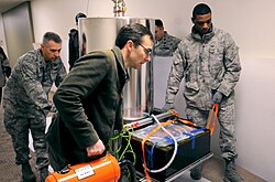 A team of United States Air Force airmen carrying a rubidium clock