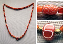 The etched carnelian beads with white designs in this necklace from the Royal Cemetery of Ur, dating to the First Dynasty of Ur, are thought to have come from the Indus Valley. British Museum.[90]