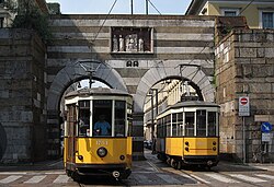 Intersecting trams under the arcs of Porta Nuova medieval gate. This type of historical tram is also used in San Francisco, United States[286]