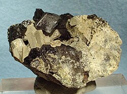 Grayish-white nepheline crystals with dark schorlomite from Bou-Agrao Mount, Tamazeght complex, High Atlas Mountains, Morocco. Size: 6.0 cm × 4.4 cm × 3.8 cm (2.4 in × 1.7 in × 1.5 in)
