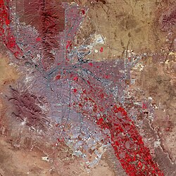 False-color satellite image of El Paso (upper right) and Ciudad Juárez (lower left): Paved streets and buildings appear in varying shades of blue-gray, and red indicates vegetation.