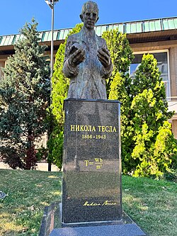 Statue of Nikola Tesla outside the National Library of Serbia; inscribed on the plaque is the formula T = W b / m 2 {\textstyle \mathrm {T={Wb}/{m^{2}}} }