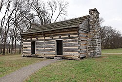 Two-door wooden cabin with stone fireplace and no windows