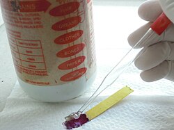 Domestic acidic drain cleaners usually contain sulfuric acid at a high concentration which turns a piece of pH paper red and chars it instantly, demonstrating both the strong acidic nature and dehydrating property.