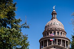 The Texas flag flying below the US flag at the Texas State Capitol