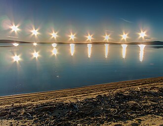 Multiple exposure of midnight sun on Lake Ozhogino in Yakutia, Russia