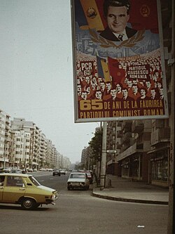 A propaganda poster on the streets of Bucharest, 1986. The caption reads "65 years since the creation of the Romanian Communist Party", while the background states "Ceaușescu Era" and "The Party. Ceaușescu. Romania."