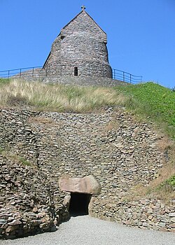 Restored entrance to the Neolithic tomb (with a mediaeval chapel on the mound) at La Hougue Bie.