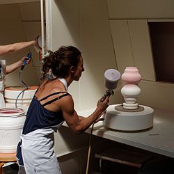 Spraying glaze onto a vase