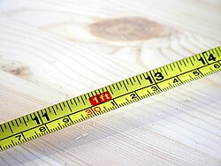 A tape measure with markings in inches, feet and centimeters