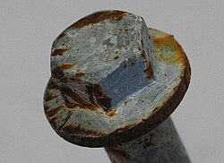 Zinc flake coated bolt with red rust after testing