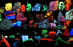 A collection of mineral samples fluorescing brilliantly at various wavelengths as seen while being irradiated by UV