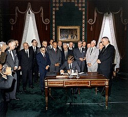 Kennedy signs the Partial Test Ban Treaty, a major milestone in early nuclear disarmament, on October 7, 1963