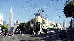Looking southeast from Columbus Avenue (on the left) and Stockton (on the right). The Transamerica Pyramid is visible in the background on Columbus Avenue. The array of overhead wires supply power for the electric trolley buses such as the one seen on Stockton Street.