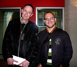 Gibson (left) influenced cyberpunk[132] and postcyberpunk writers such as Cory Doctorow (right),[135] whom he also consulted for technical advice while writing Spook Country.[136]