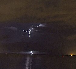A bolt from the blue lightning strike which appears to initiate from a clear patch of sky, but the turbulent sky above the anvil cloud drives a bolt of plasma through the cloud directly to the ground. They are commonly referred to as positive flashes, despite the fact that they are usually negative in polarity.