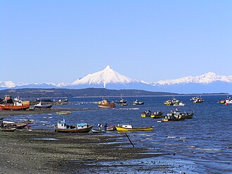 Fishing boats in Quellón. Corcovado Volcano in the background.