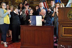 Governor Tim Walz signing a bill into law in 2022