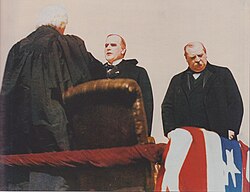 Chief Justice Melville Fuller swears in William McKinley as president; outgoing President Grover Cleveland at right